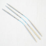 Set of metal knitting needles on a white background