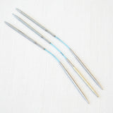 Set of metal knitting needles on a white background