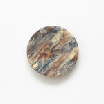 Marbled patterned button on a white background