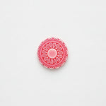 Red decorative circular flower design on a white background