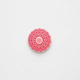 Red decorative circular flower design on a white background