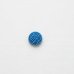 Blue beaded button on a white background
