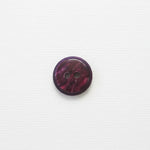 Round purple button with two holes on a white background