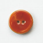 Orange button with two holes on a white background
