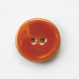 Orange button with two holes on a white background