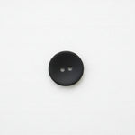 Black matte button with two holes on a white background