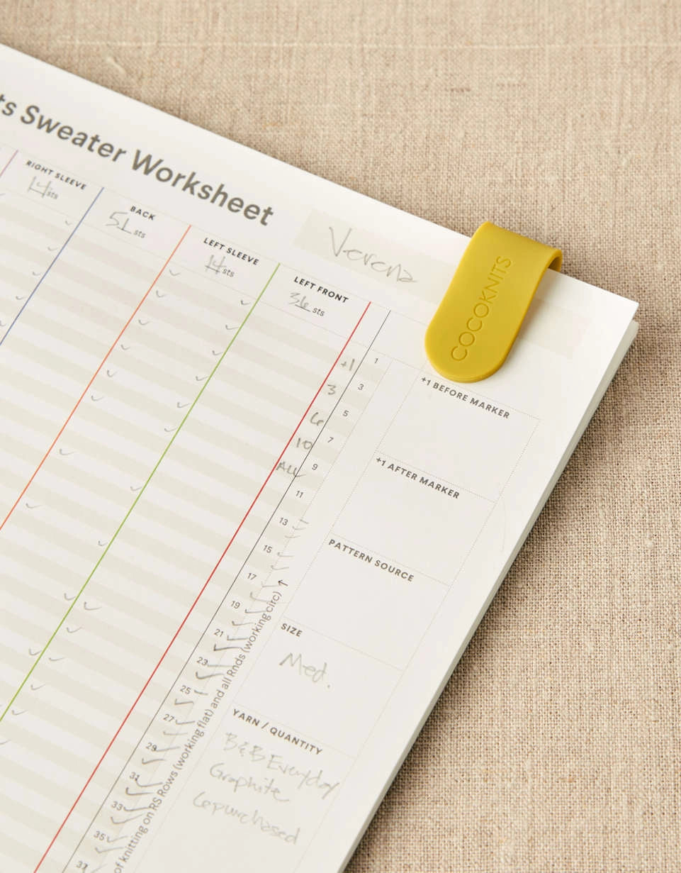 Sheet of paper with a sweater pattern  worksheet slipped together on a textured surface