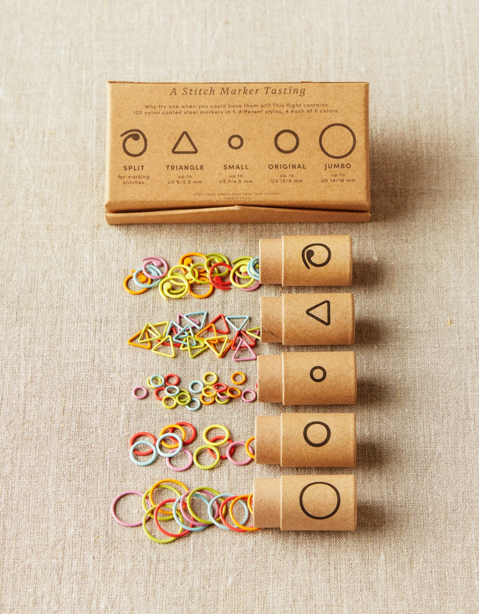 Set of stitch markers with packaging on a fabric background