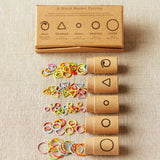 Set of stitch markers with packaging on a fabric background
