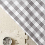 Gray and white checkered fabric with a coin and puzzle piece on a beige background