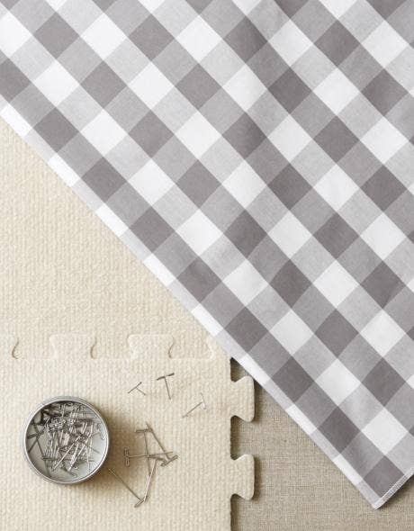 Gray and white checkered fabric with a coin and puzzle piece on a beige background
