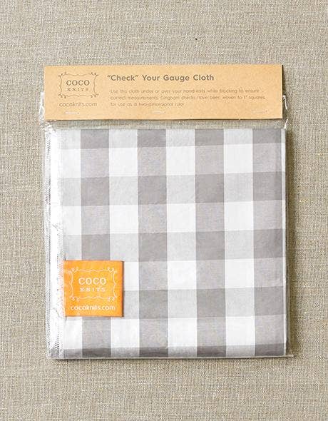 Packaged checkered cloth with COCO label on a textured fabric background