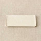 Rectangular ceramic plate on a beige textured surface