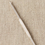 Steel repair hook on a beige fabric background