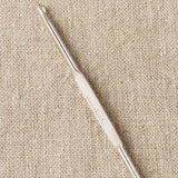 Steel repair hook on a beige fabric background