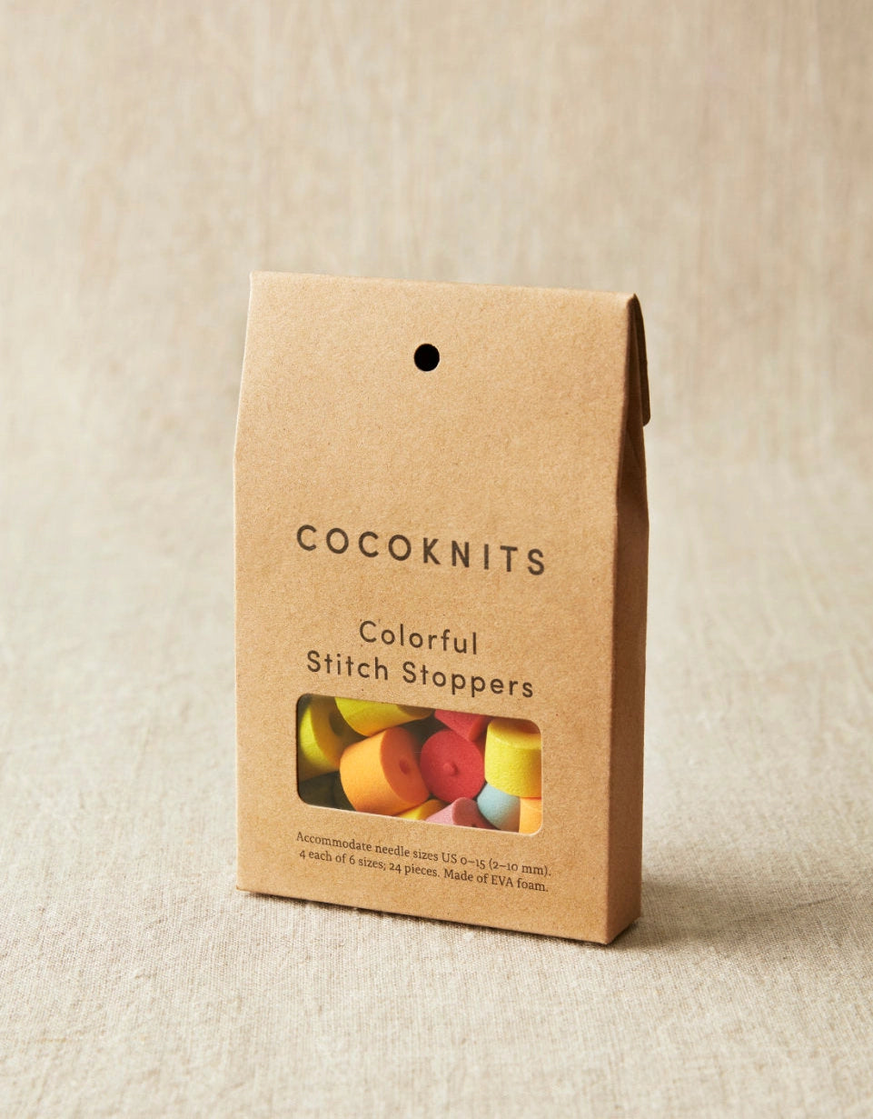 Cocoknits packaging with colorful stitch stoppers on a beige background