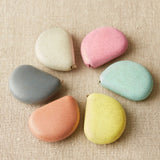 Set of colorful tape measures on a textured beige surface