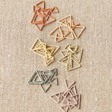 Set of colored triangle stitch markers on a textured beige background
