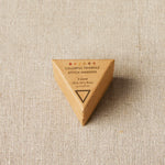 Triangular wooden container with 'Colorful Triangle Stitch Markers' text on a beige fabric background