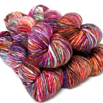 Multicolored skeins of yarn stacked on a white background