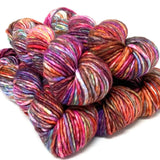 Multicolored skeins of yarn stacked on a white background