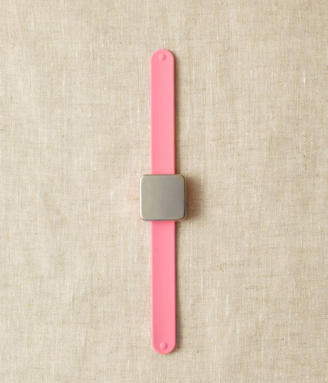 Pink slap bracelet with a square magnet.